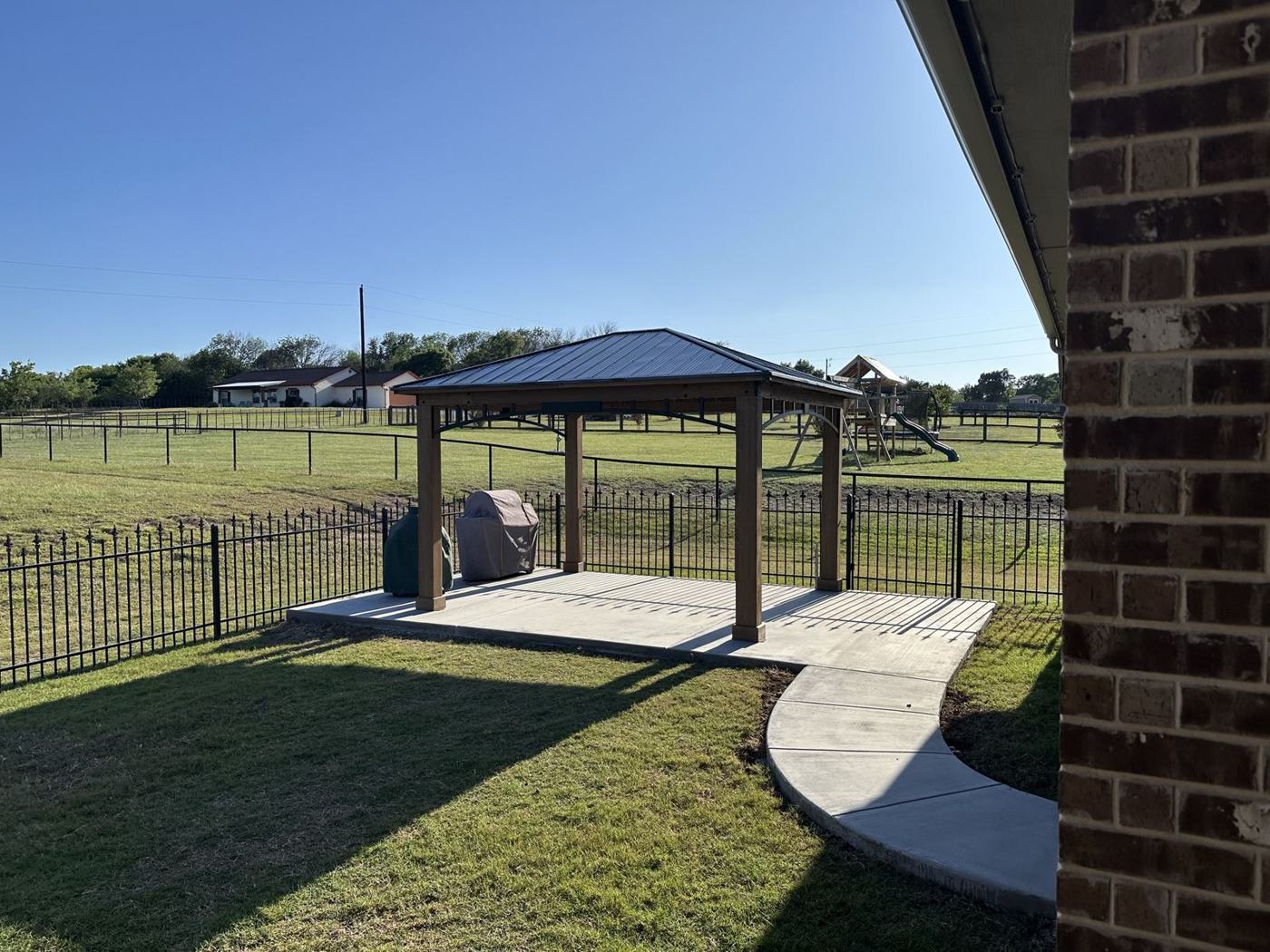 Backyard pavilion on a concrete slab with curved walkway